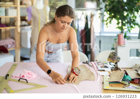 Woman dressmaker making markings on textiles Woman dressmaker making markings on textiles 126931223