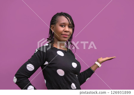 African American Woman Pointing to Copy Space on Blank Studio Background 126931899