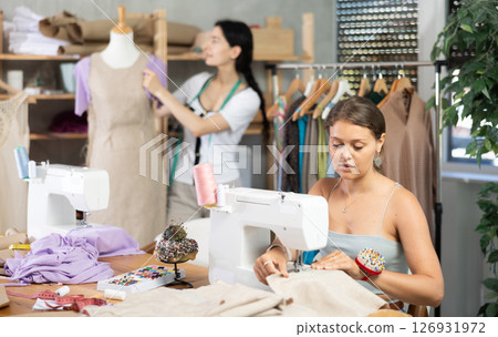 Dressmakers work in the workshop and sew clothes Dressmakers work in the workshop and sew clothes 126931972