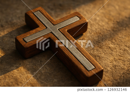 Wooden orthodox cross with metallic inlay lying on textured stone surface illuminated by warm sunlight, symbolizing faith and tradition, AI Generative 126932146