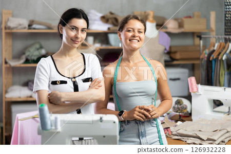 dressmakers are standing in the workshop and smiling dressmakers are standing in the workshop and smiling 126932228