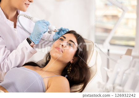 Young girl undergoing skin therapy session with application of atomized nutrients Young girl undergoing skin therapy session with application of atomized nutrients 126932242