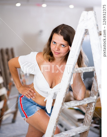 Tempting woman in revealing attire posing in construction site 126932375