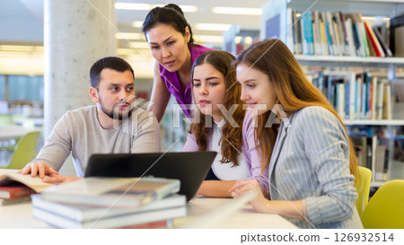 Female and male colleagues working together in public library Female and male colleagues working together in public library 126932514
