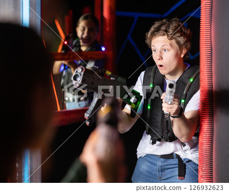 Excited teenager having fun playing lasertag in arena 126932623