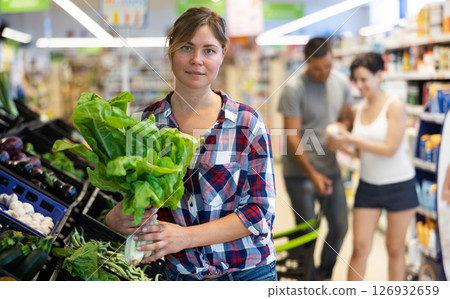 Portrait of woman with lettuce in grocery store Portrait of woman with lettuce in grocery store 126932659