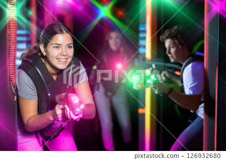 Young lady having fun playing lasertag in arena Young lady having fun playing lasertag in arena 126932680