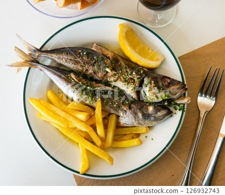 Grilled scomber with fried potatoes and lemon slice 126932743