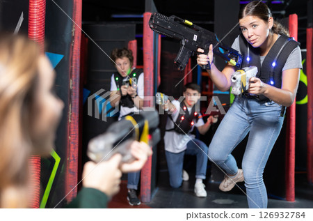 Young lady having fun playing lasertag in arena Young lady having fun playing lasertag in arena 126932784