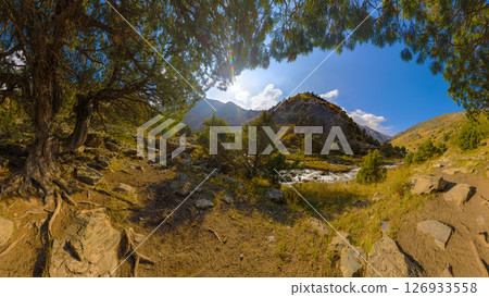 mountain landscape with flowing stream and rocky slopes under a blue sky with clouds. mountain landscape with flowing stream and rocky slopes under a blue sky with clouds. 126933558