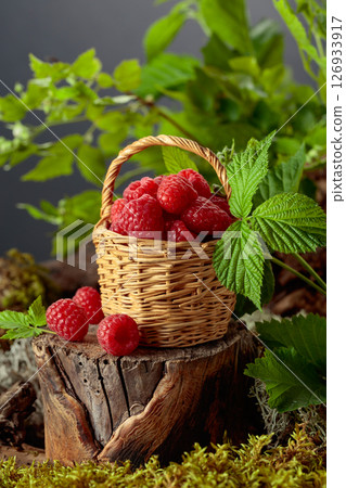 Small wicker basket filled with fresh, ripe raspberries. Small wicker basket filled with fresh, ripe raspberries. 126933917