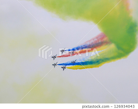 J-10 Acrobatic airshow team from China Air Force on formations with colorful smokes venting from the plane. 126934043