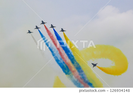 J-10 Acrobatic airshow team from China Air Force on formations with colorful smokes venting from the plane. 126934148