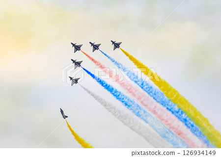 J-10 Acrobatic airshow team from China Air Force on formations with colorful smokes venting from the plane. 126934149