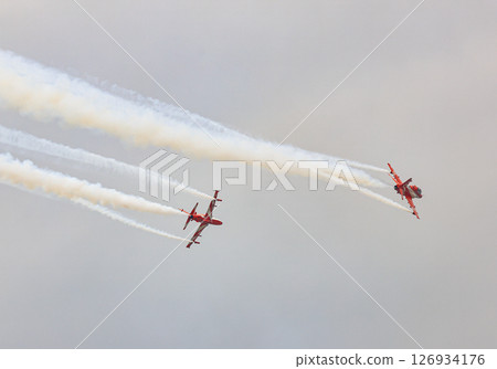 HAWK MK132 Acrobatic airshow team from India Air Force on formations with colorful smokes venting from the plane. 126934176