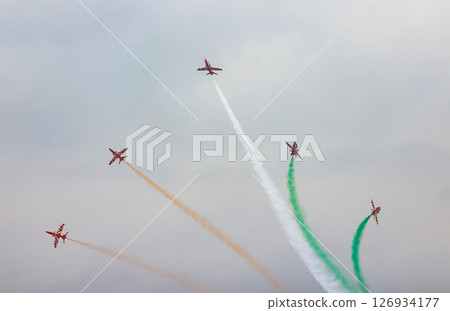 HAWK MK132 Acrobatic airshow team from India Air Force on formations with colorful smokes venting from the plane. 126934177