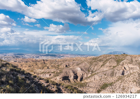 Discovering the majestic badlands of gorafe, spain, under a cloudy sky Discovering the majestic badlands of gorafe, spain, under a cloudy sky 126934217