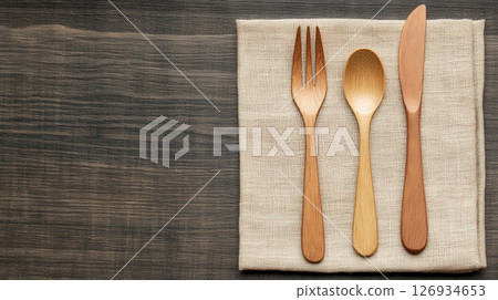 Wooden cutlery on linen napkin symbolizing sustainability Wooden cutlery on linen napkin symbolizing sustainability 126934653