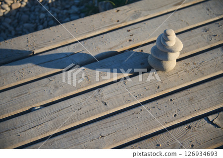 Pebble Stack on Wooden Deck in Natural Outdoors Environment Pebble Stack on Wooden Deck in Natural Outdoors Environment 126934693