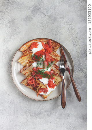 Delicious pancakes with salmon and sour cream , breakfast, on a plate, rustic style ,with cutlery Delicious pancakes with salmon and sour cream , breakfast, on a plate, rustic style ,with cutlery 126935100