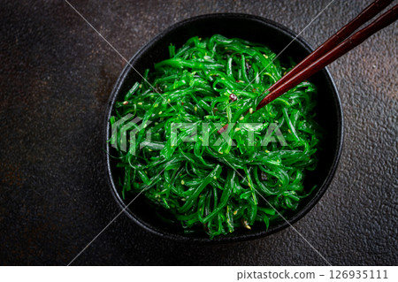 Chuka salad, made from fresh seaweed, with sesame dressing, served in a black bowl, with chopsticks, 126935111