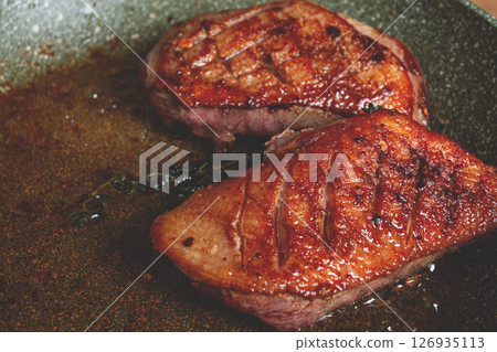 cooking duck breast, in a frying pan, fried, with spices and herbs, close-up, no people, 126935113