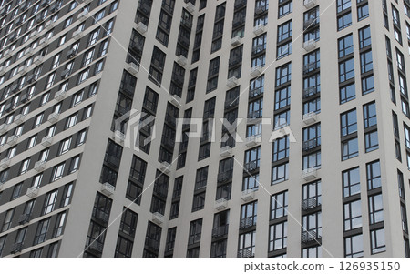 Facade of a modern high-rise building with cheap apartments and small balconies 126935150