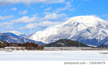 The Tokaido Shinkansen train runs with the snow-capped Mount Ibuki in the background 126936070