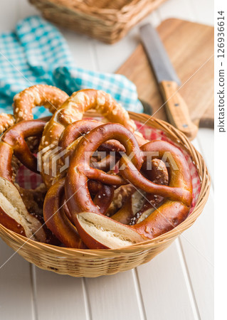 Salted bavarian pretzel in basket on kitchen table. Salted bavarian pretzel in basket on kitchen table. 126936614