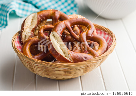 Salted bavarian pretzel in basket on kitchen table. Salted bavarian pretzel in basket on kitchen table. 126936615