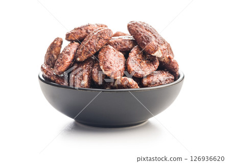 Nuts coated in sugar and honey in bowl isolated on white background. 126936620