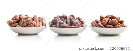 Nuts coated in sugar and honey in bowl isolated on white background. 126936623