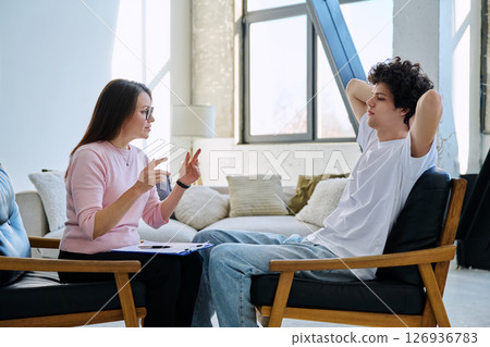 Sad young male patient in therapy session in psychologist counselor office Sad young male patient in therapy session in psychologist counselor office 126936783