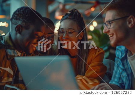 Happy business team collaborating in modern office, laughing and working together with laptops and documents on the desk. 126937283