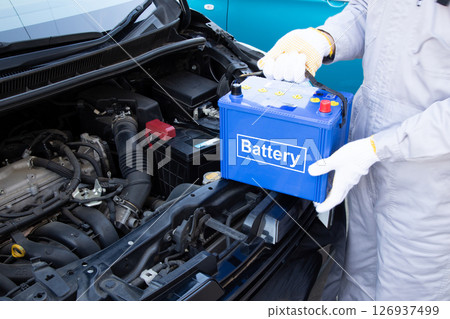 Mechanic with car and battery 126937499