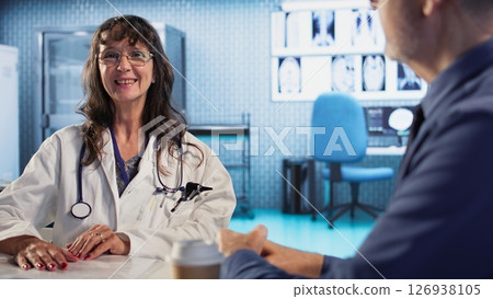 Physician meeting with elderly male patient to discuss results in a cabinet, using advanced diagnostic tools to interpret x ray imaging scans and results, professional healthcare approach. Camera A. 126938105