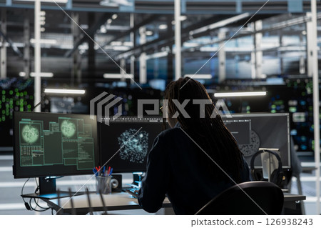 Data center IT expert looking at network traffic patterns, detecting security threats. Engineer doing AI visualization threat mapping, developing automated firewalls and intrusion detection solutions Data center IT expert looking at network traffic patterns, detecting security threats. Engineer doing AI visualization threat mapping, developing automated firewalls and intrusion detection solutions 126938243