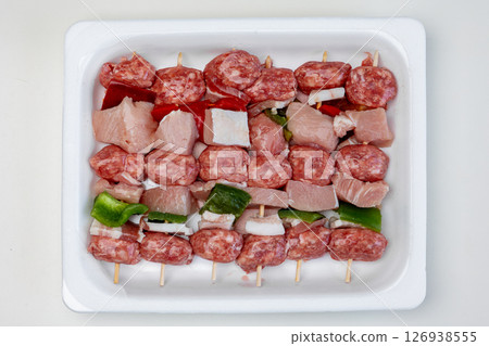 Raw meat skewers with pork, sausage, and peppers ready for grilling 126938555