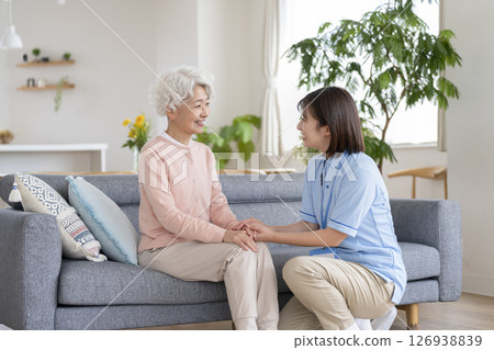Smiling senior woman and care staff talking 126938839
