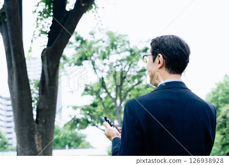 在戶外操作智能手機的商人 126938928