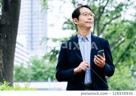 在戶外操作智能手機的商人 126938930