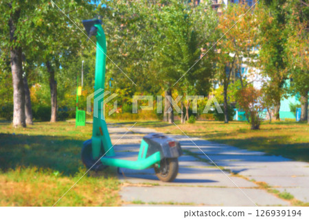 Blurred electric scooter for driving in summer city park 126939194