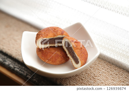 Still life of bean-jam donuts served in a white dish on a windowsill Still life of bean-jam donuts served in a white dish on a windowsill 126939874