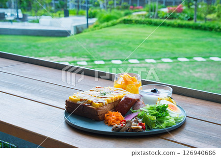 A luxurious breakfast served on the outdoor terrace of a vacation hotel during the beautiful green season. A luxurious breakfast served on the outdoor terrace of a vacation hotel during the beautiful green season. 126940686