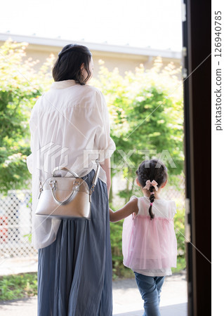 Back view of a mother and child going out in front of the house Back view of a mother and child going out in front of the house 126940785