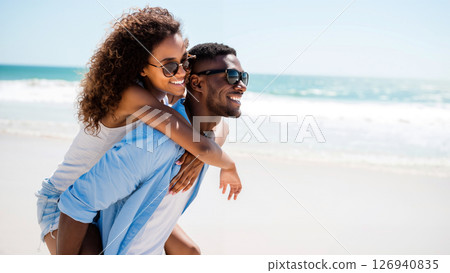 Couple Enjoys a Sunny Day at the Beach During Summer While Playfully Sharing Laughter 126940835