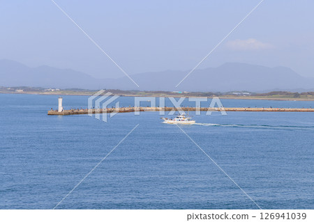 People enjoying sea fishing on a breakwater and fishing boats 126941039