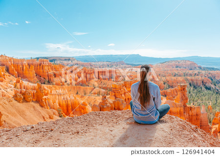 Hiker girl in Bryce Canyon hiking relaxing looking at amazing view during hike on summer travel in Bryce Canyon National Park, Utah, United States. Hiker girl in Bryce Canyon hiking relaxing looking at amazing view during hike on summer travel in Bryce Canyon National Park, Utah, United States. 126941404