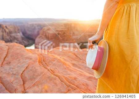 Beautiful woman in yellow dress on the edge of the cliff at Horseshoe Band Canyon in Paje, Arizona. Beautiful nature in USA Beautiful woman in yellow dress on the edge of the cliff at Horseshoe Band Canyon in Paje, Arizona. Beautiful nature in USA 126941405