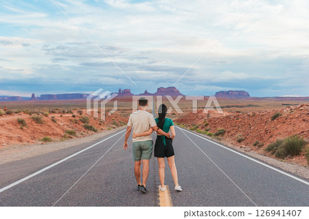 Happy couple on the famous road to Monument Valley in Utah. Amazing view of the Monument valley. Happy couple on the famous road to Monument Valley in Utah. Amazing view of the Monument valley. 126941407